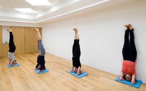 AN3MGG Women standing on their heads in yoga exercise at The Iyengar Yoga Studio, London, England, UK