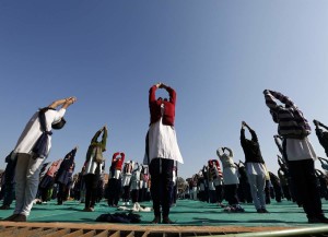 Schoolchildren offer prayers to Sun god during a yoga session at a camp in the western Indian city of Ahmedabad January 6, 2015. REUTERS/Amit Dave (INDIA - Tags: SOCIETY) - RTR4K78P