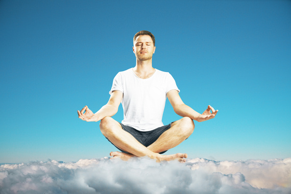 Man maditates on the clouds at blue sky background concept