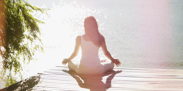 Woman practicing yoga on pier