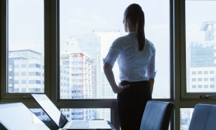 Woman in he office looking out the window.